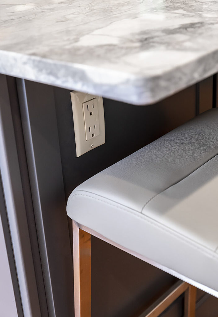 Detail of the island under-counter power, showing the beautiful patterns of the Super White Quartzite counter.