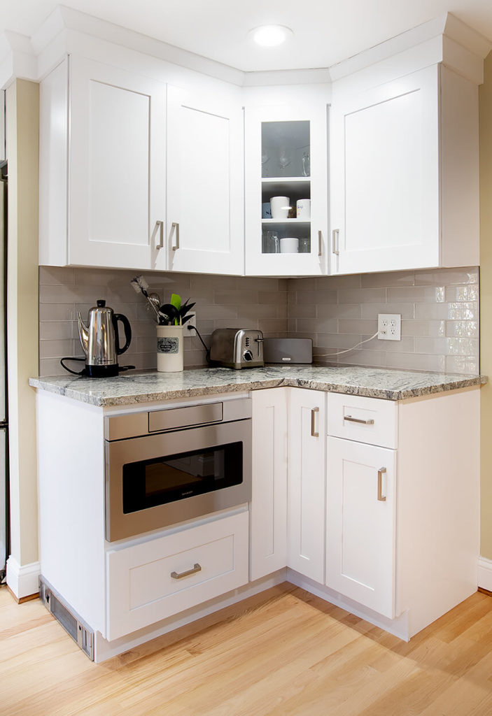 Corner cabinet area showing glass cabinet door front for showcasing valuables, and custom designed tote kick heater vent.