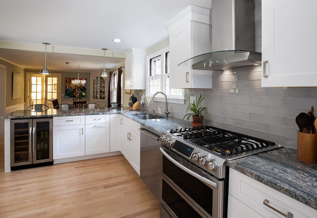 White Wave granite counters extend from the work area to the peninsula island, creating extra working space and a handy breakfast bar.