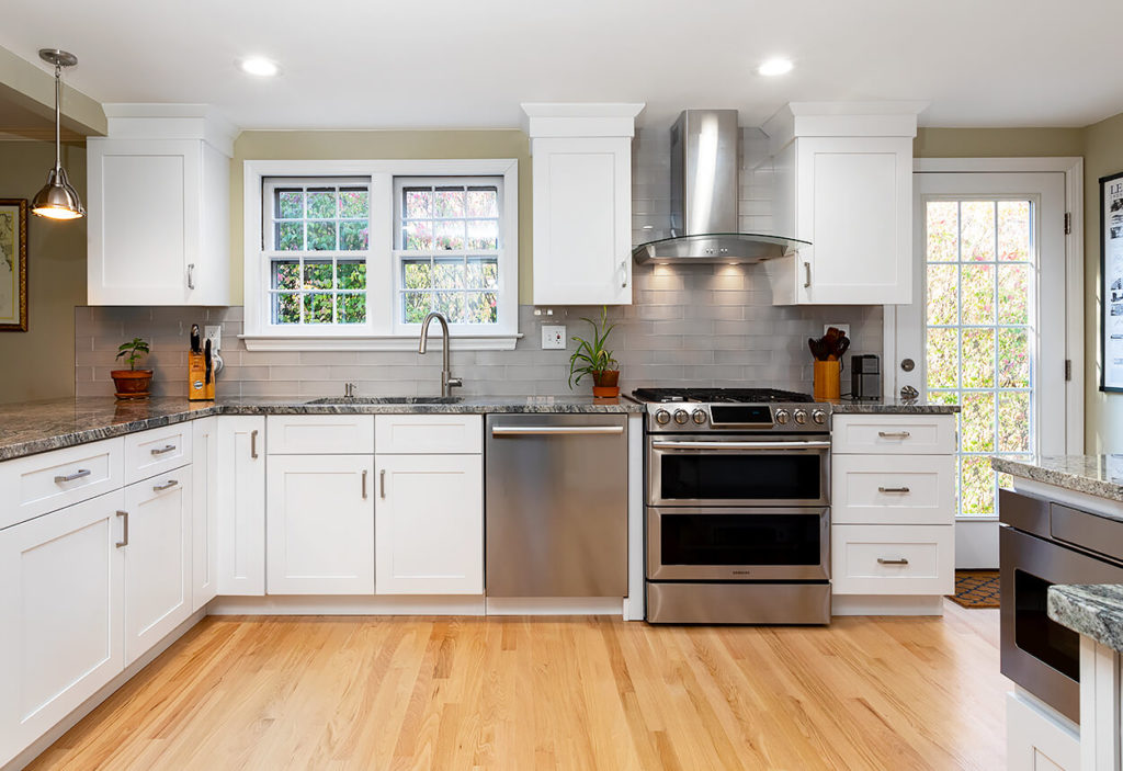 New kitchen cabinets and counters in this West Hartford kitchen remodel, with custom glass hood over the range.